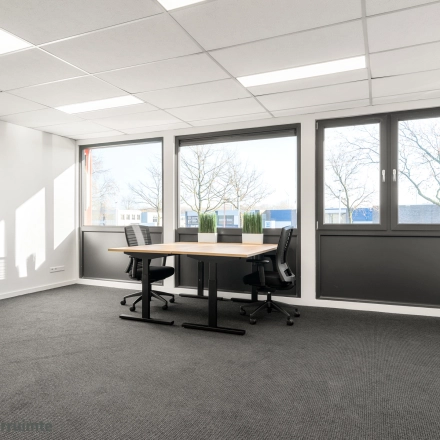 Bright office space at Nijverheidsweg 9B, Nieuwegein available for rent. Features large windows and minimalist furnishings ideal for productive work.