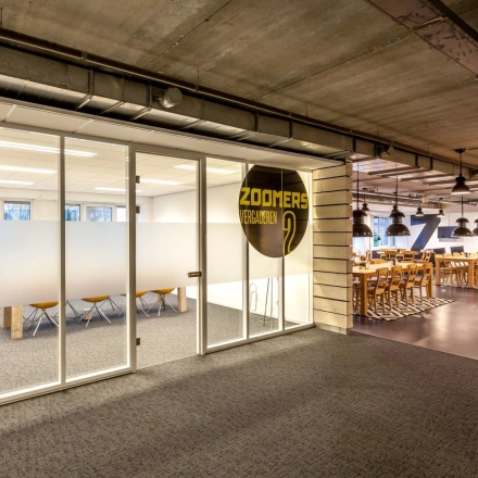 Spacious and modern interior of an office building at Zoomstede 19, Nieuwegein, featuring a stylish conference room with wooden chairs and a bright, open-floor design, ideal for office space rental.