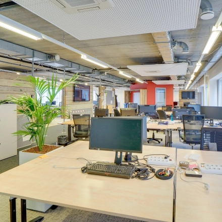 A spacious office interior on Zoomstede 19, Nieuwegein, featuring open workspaces with multiple desks, computer monitors, and a potted plant under modern lighting. Ideal for office space rental.