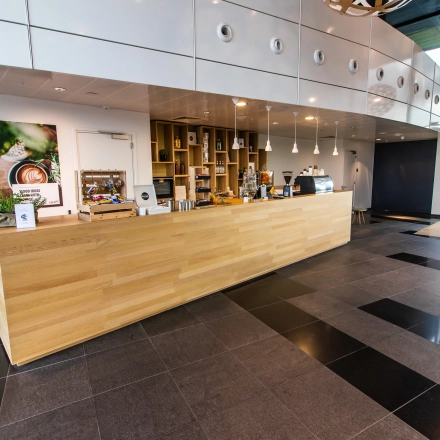 Modern office space at Jonkerbosplein 52, Nijmegen features a sleek wooden counter ideal for a reception area, available for rent as part of attractive office space rental offerings.