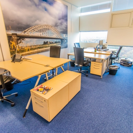Bright office space at Jonkerbosplein 52 in Nijmegen featuring desks, chairs, and cityscape artwork, ideal for office space rental.