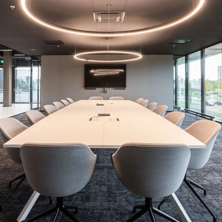 Spacious conference room at Jonkerbosplein 52, Nijmegen, featuring a large table surrounded by modern chairs under circular lights, available for office space rental.