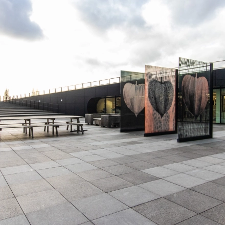 Exterior view of an office space at Jonkerbosplein 52, Nijmegen, showcasing a modern design with ample outdoor seating. Ideal for those looking to rent office space.