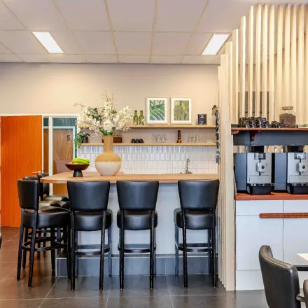 Modern furnished lounge area in an office at Leeghwaterstraat 25, Reeuwijk, with bar seating and modern decor.
