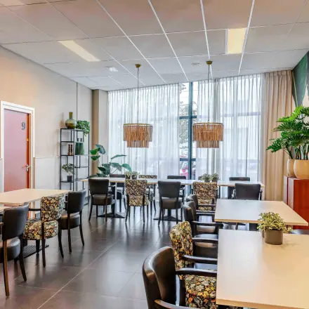 Interior of a furnished lounge area with tables and chairs at Leeghwaterstraat 25, ideal for office space rental.