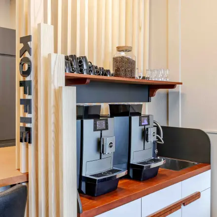 Coffee station with modern machines and wooden accents, ideal for an office space rental at Leeghwaterstraat 25, Reeuwijk.