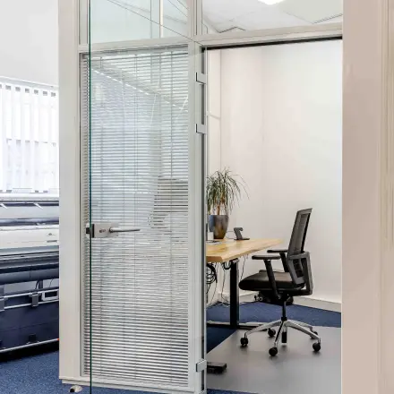 Modern office space at Leeghwaterstraat 25, Reeuwijk, featuring a desk and office chair with natural light pouring through large windows.