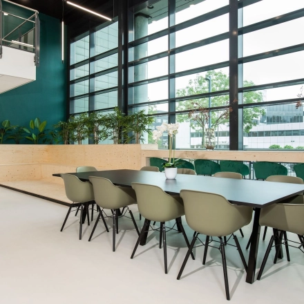Modern office space for rent at Einsteinlaan 28 in Rijswijk, featuring a spacious furnished interior with a long conference table and large windows letting in natural light.