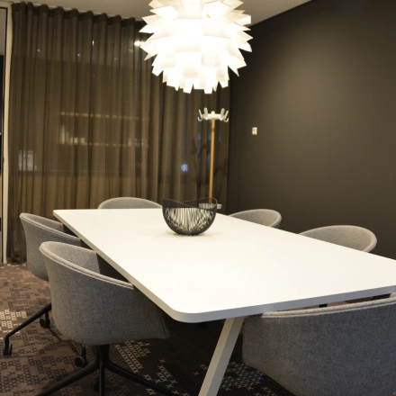 Modern office space to rent at Laan van Vredenoord 33, Rijswijk, featuring a sleek meeting table and chairs under stylish lighting.