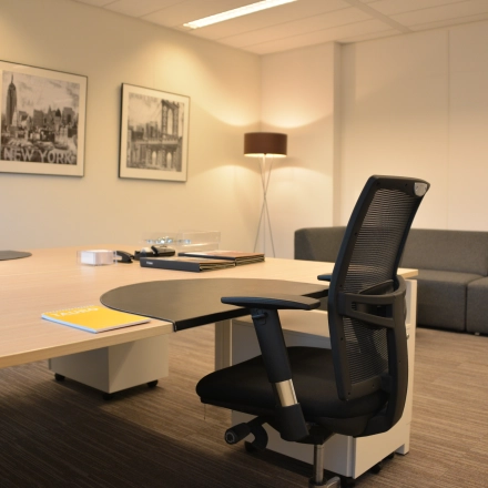 Interior of a furnished office at Laan van Vredenoord 33, Rijswijk, featuring a desk, a chair, and a comfortable sofa. Ideal for office space rental with modern amenities.