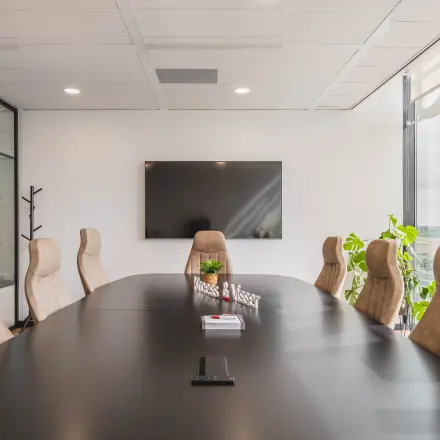 Modern conference room at Laan van Zuid Hoorn 70, Rijswijk, featuring a large table, comfortable chairs, and a sleek TV. Ideal office space rental for meetings.