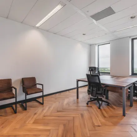 A furnished office space with a meeting table and chairs, located at Laan van Zuid Hoorn 70, ideal for office space rental.