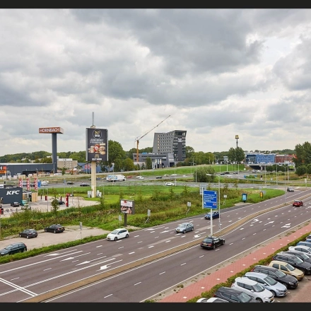 Exterior view near Patrijsweg 62 in Rijswijk, showcasing nearby businesses and ample parking space, ideal for those exploring office space rental options.