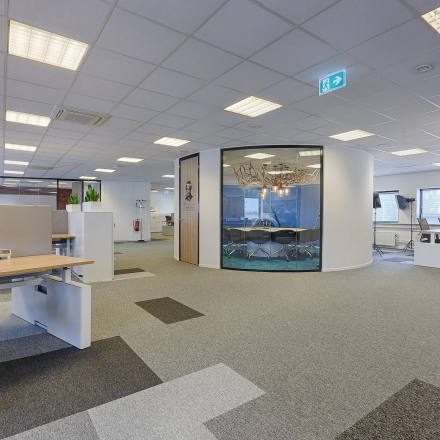 Modern office space for rent at Patrijsweg 62, Rijswijk, featuring open floorplan with workstations and a glass-walled conference room.