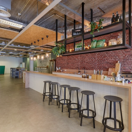 Furnished office space at Patrijsweg 62, Rijswijk, featuring a modern lounge area with a long counter and bar stools, exposed ceilings, and decorative lighting.