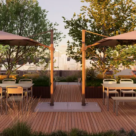 Open rooftop area at Marten Meesweg 101 in Rotterdam Alexander, featuring wooden decking, tables, chairs, and umbrellas, perfect for an office space rental. There are no people visible.