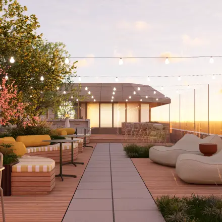 Rooftop terrace at Marten Meesweg 101, Rotterdam Alexander, featuring seating arrangements, plants, and string lights, ideal for office space rental with a scenic view.