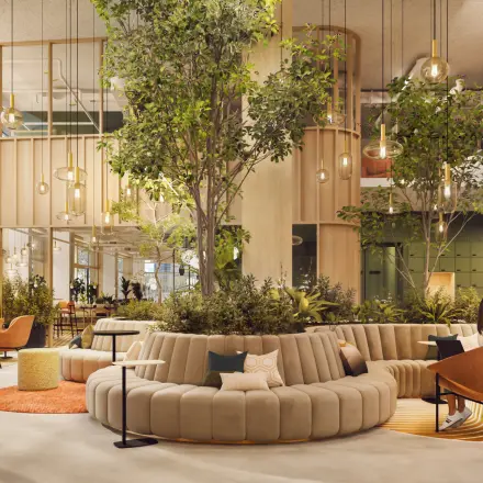 Modern lobby area at Marten Meesweg 101, Rotterdam Alexander, featuring stylish seating and natural elements. Ideal office space rental environment with people engaged in casual discussions.