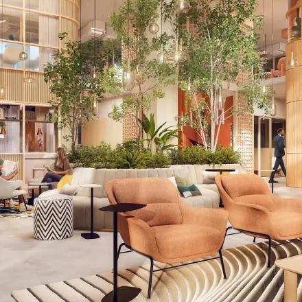 Modern office in Rotterdam Alexander with natural elements, featuring comfortable seating and people engaged in discussions. Ideal for office space rental.