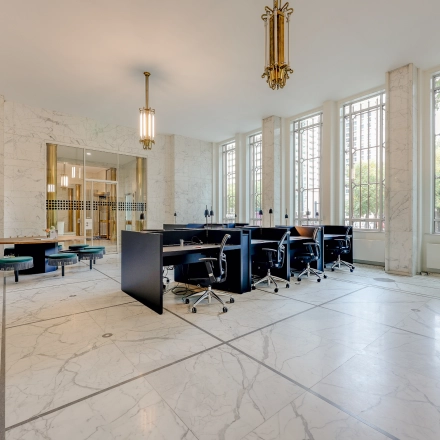 Bright office space with marble flooring and modern furnishings, available for rent at Blaak 34, Rotterdam Center. Large windows enhance the workspace's appeal for office space rental.
