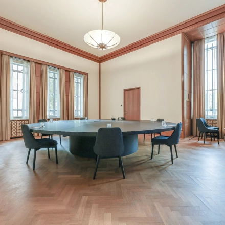Spacious office to rent at Blaak 34 in Rotterdam Center, featuring a large table surrounded by chairs with natural light from tall windows, ideal for office space rental.