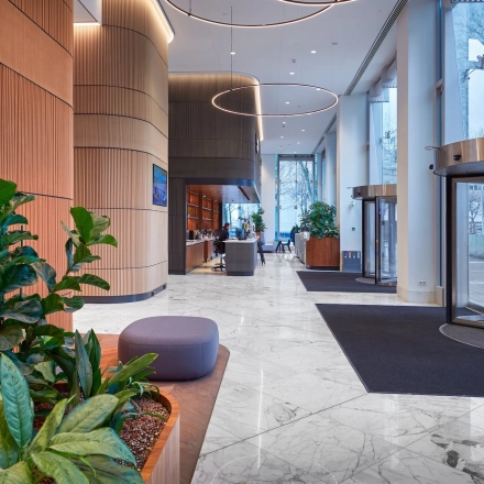 Spacious reception area at Blaak 555, Rotterdam Center, featuring modern decor and plant accents. Ideal for businesses seeking office space rental.