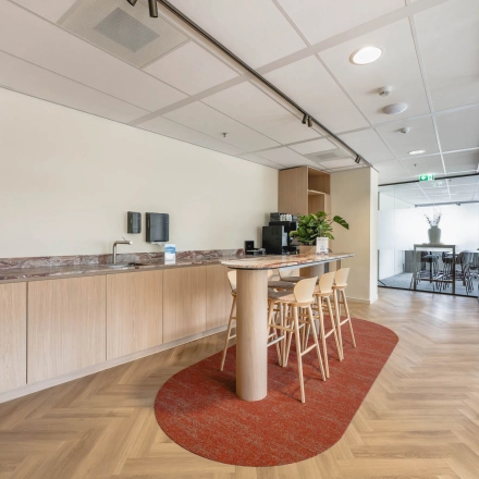 Bright office space at Blaak 555, Rotterdam Center, featuring an inviting lounge area with modern furniture and sleek design, ideal for office space rental.