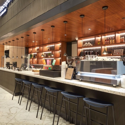 Modern reception area at Blaak 555 in Rotterdam Center with a sleek counter and stylish lighting, ideal for office space rental.