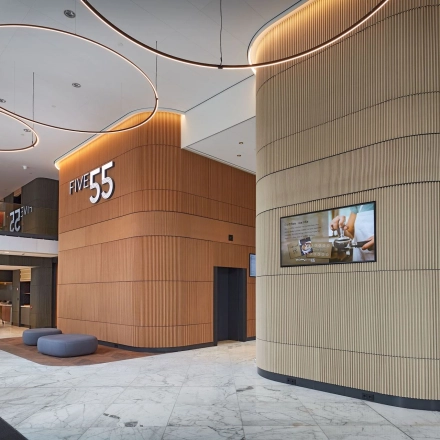Modern office lobby at Blaak 555, Rotterdam Center with wooden accents and LED lighting, ideal for rent office space.