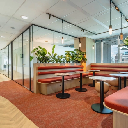 Modern furnished office space at Blaak 555, Rotterdam Center, featuring stylish seating areas and greenery. Ideal office space rental opportunity.