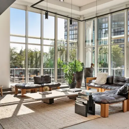 Bright office space at Coolsingel 104 in Rotterdam Center with large windows, modern furniture, and a cozy seating area ideal for meetings. Ideal for office space rental.