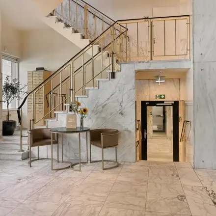 A stylish entryway with marble floors and walls at an office space available for rent on Coolsingel 104, Rotterdam Center.