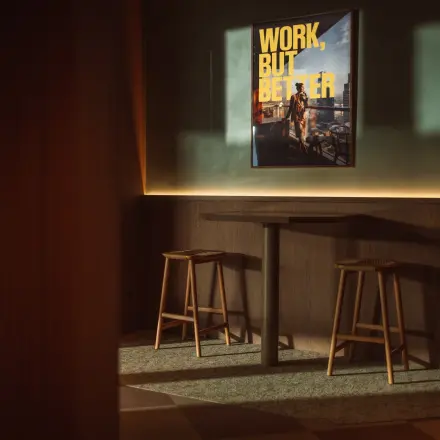 Cozy corner with stools and a high table beneath a motivational poster in an office to rent at Coolsingel 139, Rotterdam Center.