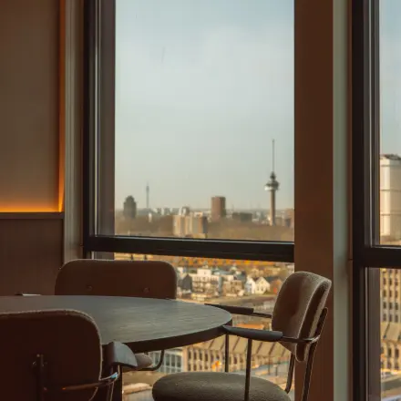 Furnished office space at Coolsingel 139, Rotterdam Center, featuring large windows with a city view, ideal for rent office space with functional work areas.