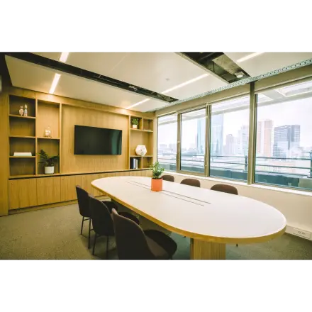 Modern furnished office space at Coolsingel 65, Rotterdam Center, featuring a large table, chairs, shelves, and a window view of the city skyline, ideal for office space rental.