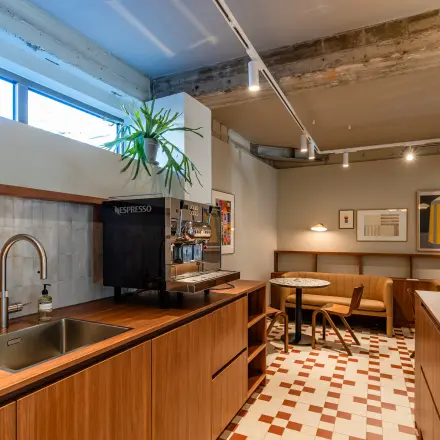 Furnished office space with a wooden counter, tiles, and a coffee station at Stadhuisplein 9-23, ideal for rent office space in Rotterdam Center.