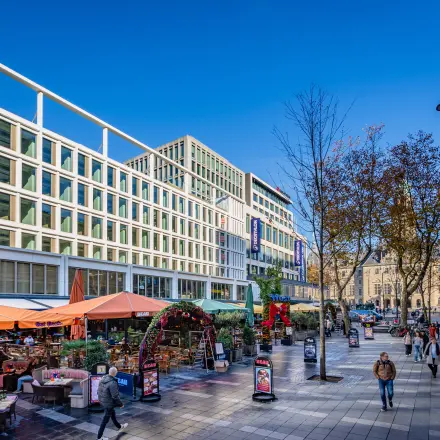View of Stadhuisplein 9-23 in Rotterdam Center, showing a bustling outdoor scene with nearby office spaces to rent.