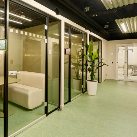 Modern office space at Weena 335, Rotterdam Center, featuring glass-enclosed booths ideal for meetings or independent work, available for rent.