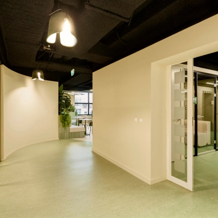 Bright office space for rent at Weena 335, Rotterdam Center featuring modern lighting, glass walls, and a plant accent, ideal for office space rental.