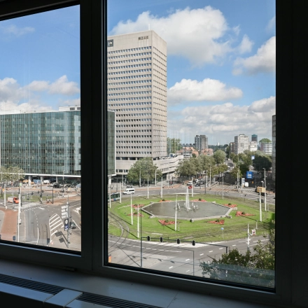 View from an office window at Weena 70, overlooking Rotterdam Center's bustling streets, ideal for office space rental.