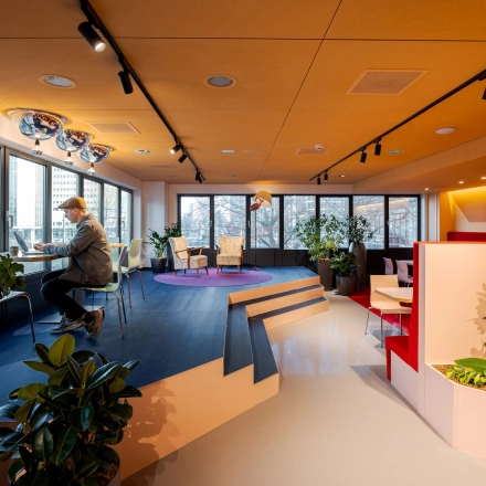 Bright office space at Weena 70 in Rotterdam Center, featuring modern furnishings, large windows and a professional working area with an individual at a desk. Ideal for office space rental.
