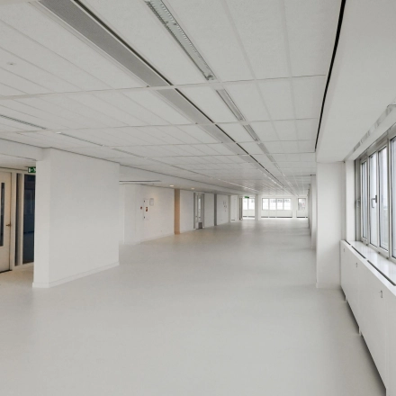 Spacious office to rent in Weena 70, Rotterdam Center. The unfurnished interior features large windows and a bright open floor plan, ideal for office space rental.