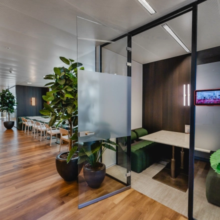 Modern office space for rent in Rotterdam Center at Weena 788, featuring a glass meeting room, plants, and natural light, ideal for office space rental.