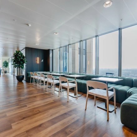 Bright office lounge at Weena 788, Rotterdam Center with modern seating arrangements and large windows, ideal for office space rental.