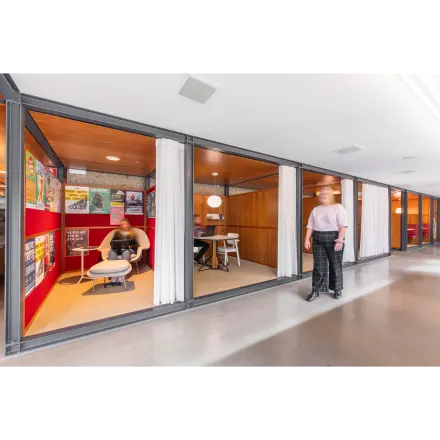 Interior view of office space at Hofplein 20, Rotterdam Central Station, with furnished meeting areas and a person talking and another seated. Ideal for office space rental.