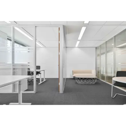 Modern office space at Weena 290, Rotterdam Central Station, features a furnished open design with desks and a lounge area, perfect for office space rental.