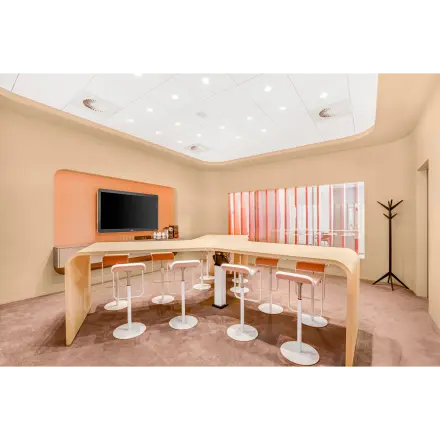 Modern furnished office space at Weena 505, Rotterdam Central Station, featuring a stylish meeting area with high stools around wooden tables.