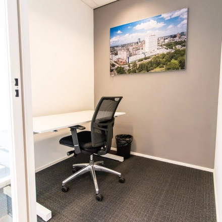 Modern, furnished office space with a desk and chair at Weena-Zuid 130, Rotterdam Central Station, available for rent.