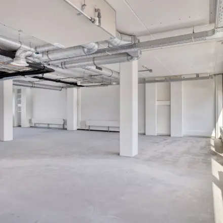 Unfurnished office space available for rent at Kratonkade 7 - 27 in Rotterdam Delfshaven, featuring large windows and industrial exposed ducts.