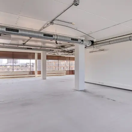 Spacious office to rent at Kratonkade 7 - 27 in Rotterdam Delfshaven, featuring an open floor plan with large windows.